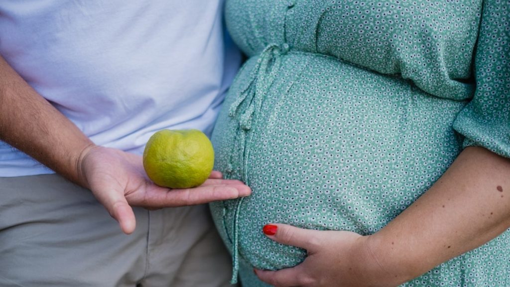 person holding yellow round fruit
